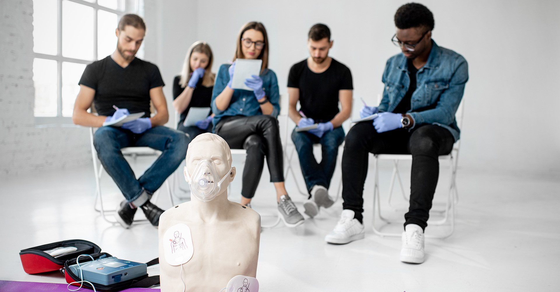 A group of people evaluating an AED pack