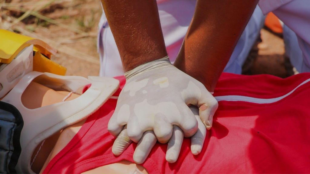 person practicing CPR on a dummy