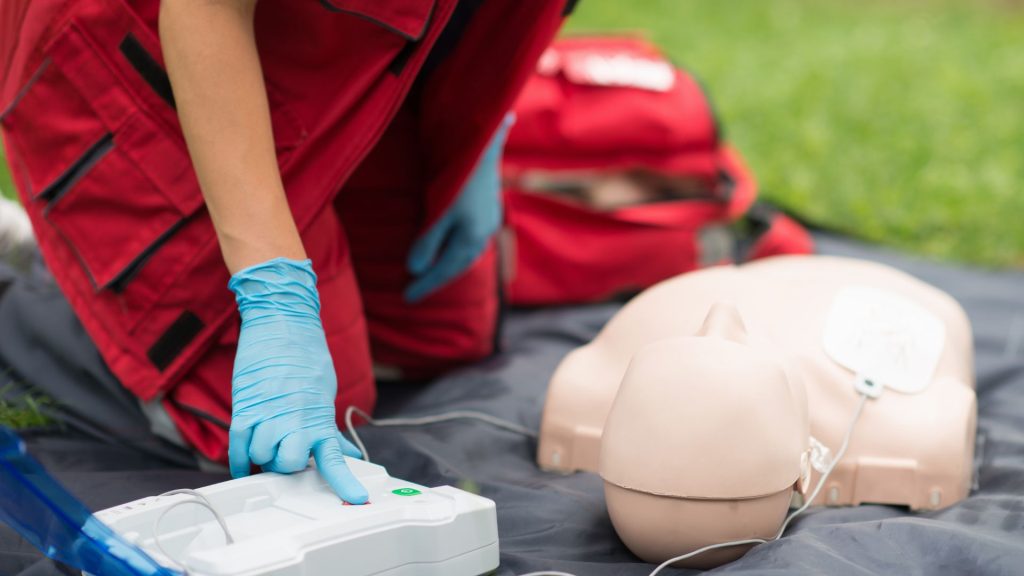 person using AED on a CPR dummy